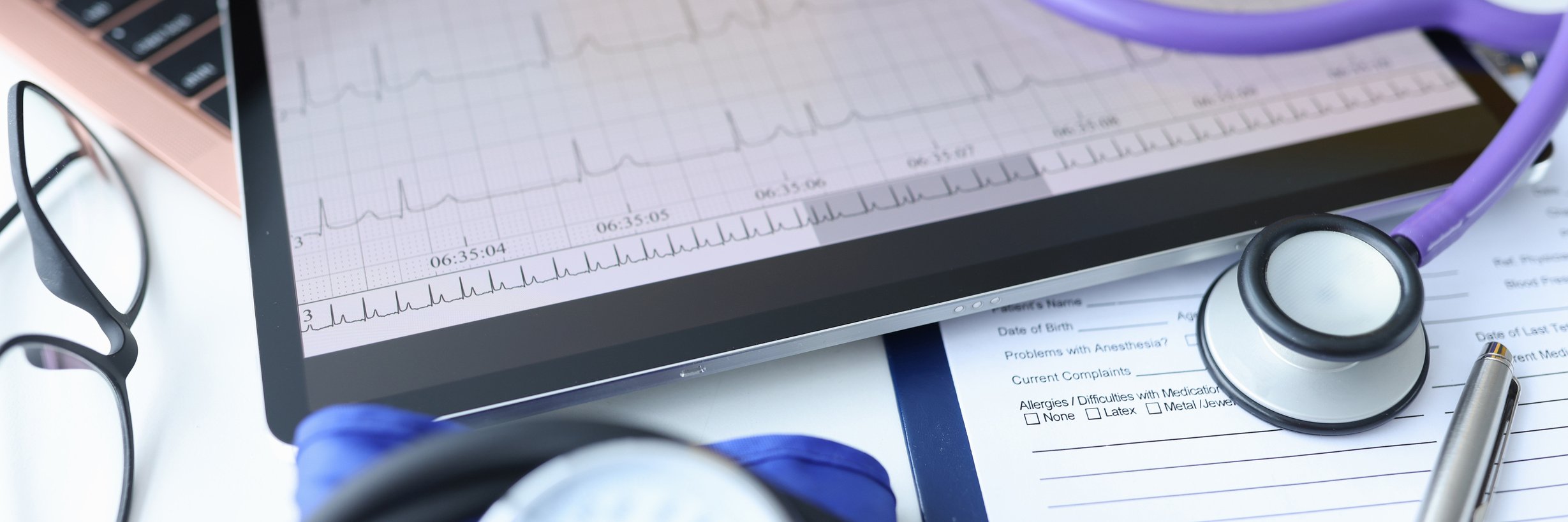 Digital Tablet with Electrocardiogram Lying on Doctors Desk Closeup